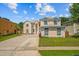 An exterior front view showcasing an elegant two-story home with a driveway and landscaping at 1240 Falconcrest Blvd, Apopka, FL 32712