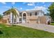 An exterior front view showcasing an elegant two-story home with a driveway, lawn and landscaping at 1240 Falconcrest Blvd, Apopka, FL 32712