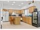 Bright kitchen with light wood cabinets, island with seating, and stainless-steel appliances for a modern touch at 1240 Falconcrest Blvd, Apopka, FL 32712