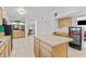 Bright kitchen with light wood cabinets, island with seating, and a beverage refrigerator, perfect for entertaining at 1240 Falconcrest Blvd, Apopka, FL 32712