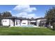 A luxurious outdoor oasis with a sparkling pool, shaded lounge area, and beautifully landscaped backyard at 12818 Brunello Cir, Clermont, FL 34711
