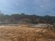 A construction site with a foundation under construction, with nearby homes in a wooded neighborhood at 12818 Brunello Cir, Clermont, FL 34711