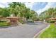 Gated community entrance with lush landscaping, mature trees, and a well-maintained brick gatehouse at 134 Heron Bay Cir, Lake Mary, FL 32746