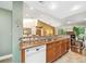 Open kitchen featuring granite countertops, mosaic backsplash, stainless steel sink, and wood cabinetry at 134 Heron Bay Cir, Lake Mary, FL 32746