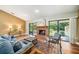 Cozy living room featuring a brick fireplace, hardwood floors, and sliding glass doors to the outside at 134 Heron Bay Cir, Lake Mary, FL 32746