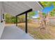 Covered back patio with view of fenced backyard with mature trees at 1340 Bakersfield Ave, Deltona, FL 32725