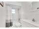 Modern bathroom with white vanity, toilet, tub and shower with modern gray curtain at 1340 Bakersfield Ave, Deltona, FL 32725