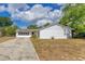 A charming single-story home boasts a long driveway and a well-maintained lawn, perfect for Gathering living at 1340 Bakersfield Ave, Deltona, FL 32725