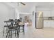 Open concept kitchen with tile flooring flowing into a dining area with stools and table at 1340 Bakersfield Ave, Deltona, FL 32725