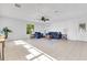 Airy living room featuring tile floors, a modern ceiling fan, and cozy blue furnishings at 1340 Bakersfield Ave, Deltona, FL 32725