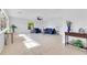 Bright living room with neutral tile flooring, ceiling fan, and cozy blue seating at 1340 Bakersfield Ave, Deltona, FL 32725