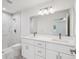 Bathroom featuring double sinks, modern lighting, large mirror and tiled shower at 13881 Sw 80Th Ave, Ocala, FL 34473