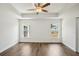 Bright bedroom features a ceiling fan, wood-look flooring, and two windows at 13881 Sw 80Th Ave, Ocala, FL 34473
