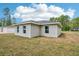 Corner view of home with backyard and simple gray color scheme, under a bright blue sky at 13881 Sw 80Th Ave, Ocala, FL 34473