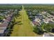 Aerial view shows community homes with mature trees and green space with powerlines extending into the distance at 14003 Sobrado Dr, Orlando, FL 32837