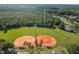 Well maintained baseball field with orange clay, lush trees and parking for community residents at 14003 Sobrado Dr, Orlando, FL 32837