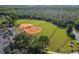 Overhead view of well-maintained baseball field with green grass, lush trees, and surrounding walkways at 14003 Sobrado Dr, Orlando, FL 32837
