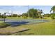 Outdoor basketball court with multiple hoops surrounded by green grass and mature trees at 14003 Sobrado Dr, Orlando, FL 32837