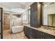 Bathroom features a soaking tub with wooden-look tile, dark cabinets, and dual sinks at 14003 Sobrado Dr, Orlando, FL 32837