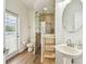 Modern bathroom featuring walk-in shower, wood floors and a pedestal sink at 14003 Sobrado Dr, Orlando, FL 32837