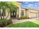 Front entrance of home featuring double glass front doors, two-car garage and lush landscaping at 14003 Sobrado Dr, Orlando, FL 32837