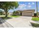 Charming single-story home featuring a large driveway and lush landscaping at 14003 Sobrado Dr, Orlando, FL 32837