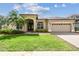 Beautiful single-story home featuring a well-manicured lawn, lush landscaping, and an attached two-car garage at 14003 Sobrado Dr, Orlando, FL 32837
