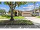 Charming single-story home with a well-manicured lawn and a mature shade tree in the front yard at 14003 Sobrado Dr, Orlando, FL 32837