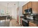 Galley kitchen featuring granite countertops, stainless steel appliances and wood-look tile flooring at 14003 Sobrado Dr, Orlando, FL 32837