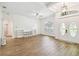 Bright and spacious living room featuring wood flooring, tray ceilings, arched doorways, and modern light fixture at 14003 Sobrado Dr, Orlando, FL 32837