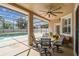 Inviting screened patio with a ceiling fan, dining set, and serene views of the pool and backyard at 14003 Sobrado Dr, Orlando, FL 32837