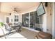 Covered patio boasts a dining set, ceiling fan, outdoor television, and sliding glass doors with views of the pool at 14003 Sobrado Dr, Orlando, FL 32837