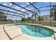 Sparkling screened pool with a waterfall feature, surrounded by a spacious deck and lush landscaping, ideal for relaxation at 14003 Sobrado Dr, Orlando, FL 32837