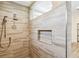 Modern shower featuring light stone-look tile, rainfall shower head and built-in shampoo niche at 14003 Sobrado Dr, Orlando, FL 32837
