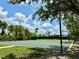 Exterior view of a community basketball court with mature trees, a green lawn and landscaping at 14479 Tanja King Blvd, Orlando, FL 32828
