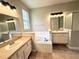 Bright bathroom featuring double sinks, soaking tub, and a separate shower area at 14479 Tanja King Blvd, Orlando, FL 32828