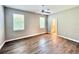 Bright bedroom featuring wood laminate flooring, two windows, and a view of an ensuite bathroom at 14479 Tanja King Blvd, Orlando, FL 32828
