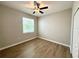 Bright bedroom with wood-look flooring, a window, and a ceiling fan at 14479 Tanja King Blvd, Orlando, FL 32828