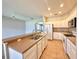 Bright kitchen featuring tile floors, white cabinets, stainless steel appliances, and breakfast bar at 14479 Tanja King Blvd, Orlando, FL 32828
