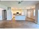 Spacious living area featuring wood laminate flooring flowing into an open kitchen with white cabinets at 14479 Tanja King Blvd, Orlando, FL 32828