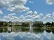 Scenic lake view featuring a fountain and colorful buildings reflected in the calm water at 14479 Tanja King Blvd, Orlando, FL 32828