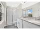 Bright bathroom features double sinks, white cabinets, gray counters, and a glass enclosed shower at 15060 Book Club Rd, Winter Garden, FL 34787