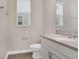 Bright bathroom featuring white vanity with stone countertop, wood-look flooring, and natural light from a window at 15060 Book Club Rd, Winter Garden, FL 34787