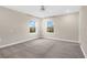 Bright bedroom features neutral walls, plush carpet, a ceiling fan, and two windows at 15060 Book Club Rd, Winter Garden, FL 34787
