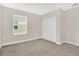 A comfortable carpeted bedroom with a window and a spacious closet at 15060 Book Club Rd, Winter Garden, FL 34787