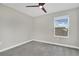 This carpeted bedroom has neutral walls, a window, and a modern ceiling fan at 15060 Book Club Rd, Winter Garden, FL 34787