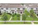 The exterior of the light grey townhome features manicured lawns and dark shutters at 15060 Book Club Rd, Winter Garden, FL 34787
