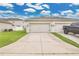 Three-car garage showcasing ample parking space with a concrete driveway, complemented by landscaping at 15060 Book Club Rd, Winter Garden, FL 34787
