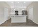 Modern kitchen with stainless steel appliances, white cabinetry, and a center island with quartz countertops at 15060 Book Club Rd, Winter Garden, FL 34787
