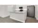 Modern kitchen with stainless steel appliances, white cabinetry, and a center island with quartz countertops at 15060 Book Club Rd, Winter Garden, FL 34787